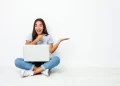 Young mixed race indian woman sitting on laptop | FintechZoom