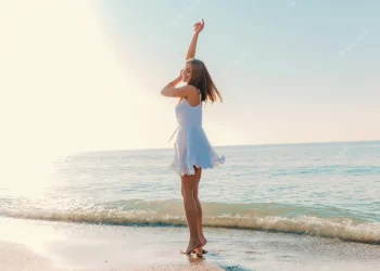 Happy woman on beach | FintechZoom