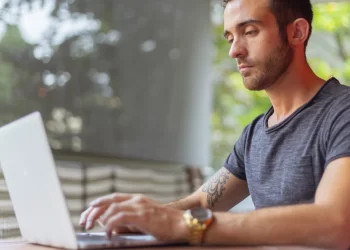 Man watching movies and tv on laptop | FintechZoom