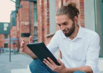 Man on tablet | FintechZoom