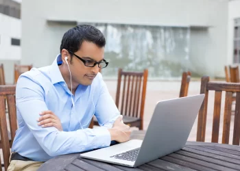 Man watching movies and tv on laptop ~ FintechZoom