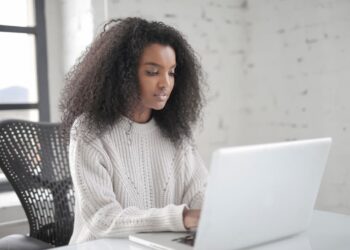 Woman using a laptop Peer-to-Peer Lending | FintechZoom