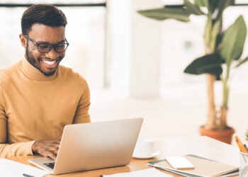 Happy person on laptop | FintechZoom