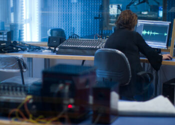 Men editing audio on computer | FintechZoom