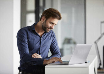 Business man using laptop | FintechZoom