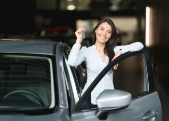 Happy Woman Holding Keys to her new car | FintechZoom