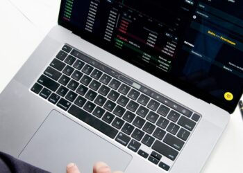 Person Using Macbook Pro on White Table in Stock Market | FintechZoom