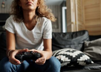 Woman Using Game Controller | FintechZoom