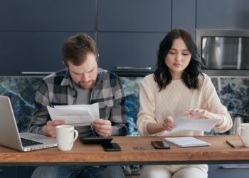 A Couple Looking at Bills | FintechZoom