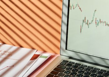 A Laptop with Stock Exchange Graph on the Screen | FintechZoom