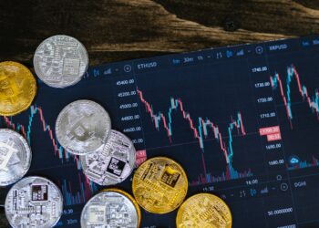 Golden and Silver bitcoins over Crypto Platform screen | FintechZoom