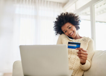 Person using credit card | FintechZoom