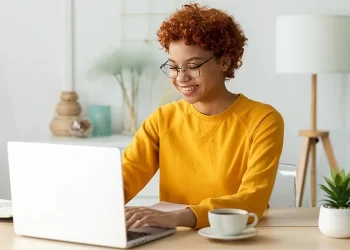 Woman at laptop in home | FintechZoom