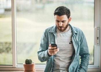 Happy guy using a smart phone | FintechZoom