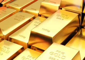 A close-up image of multiple gold bars stacked together. Each gold bar is shiny with inscriptions indicating "FINE GOLD 999.9" and their weight, with several showing "1000g". The scene highlights the bright, reflective surface of the bars, a sight familiar in commodity trading circles. | FintechZoom