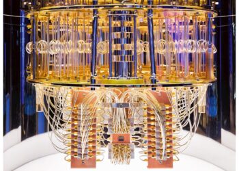 The image shows the intricate interior of an advanced quantum computer, featuring a complex array of gold-colored wiring, delicate rings, and various interconnected components. The structure appears symmetrical and highly organized, with a metallic, futuristic design, akin to a beacon for quantum computer stocks. | FintechZoom