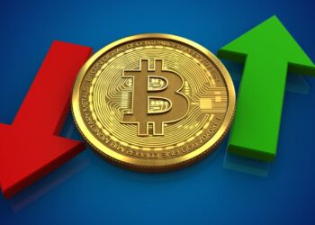 A gold Bitcoin coin is centered against a blue background. To the left of the coin is a red downward arrow, and to the right, a green upward arrow. This image symbolizes Bitcoin volatility in the crypto market and its fluctuating value in financial markets. | FintechZoom