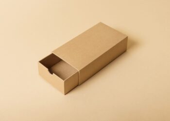 A rectangular, minimalist brown cardboard box with a drawer is partially open, revealing its contents are hidden. The word "MEMORIES" is subtly embossed on the top of the drawer, echoing the box's natural, eco-friendly design. The background is a light tan color, reminiscent of excellent customer service simplicity. | FintechZoom
