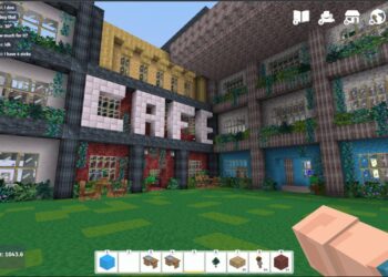 A block-style video game scene in Vectaria.io displays a three-story building with large "CAFE" letters on it. The facade includes colorful blocks and numerous windows, with greenery and furniture in an outdoor seating area. The player's hand and various game icons are visible in the foreground. | FintechZoom