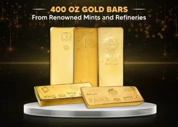 A stunning display of various 400 oz gold bars from different renowned mints and refineries. The gold bars are placed on a round, elevated platform against a black background with golden sparkles. Text above reads "400 OZ GOLD BARS From Renowned Mints and Refineries. | FintechZoom