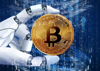 An image of a robotic hand holding a gold Bitcoin in front of a blue digital background. The Bitcoin features the iconic "B" symbol, representing the cryptocurrency, while binary code and other digital graphics emphasize the AI and crypto technological theme. | FintechZoom