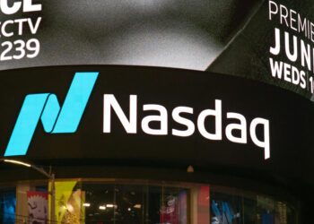 A Nasdaq sign featuring the logo and name is prominently displayed on an electronic screen in a bustling urban area at nighttime. Additional text in the upper right corner advertises an event premiere on June 23rd, shown at 10 PM on Wednesday, as highlighted by FintechZoom. | FintechZoom