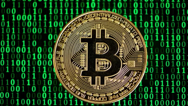 A gold Bitcoin coin with the letter "B" symbol at the center, featuring intricate engravings and binary code patterns. The background is filled with a green matrix-style digital binary code pattern, emphasizing the digital and technological aspect of cryptocurrency, making it a unique visual statement to invest in Bitcoin. | FintechZoom