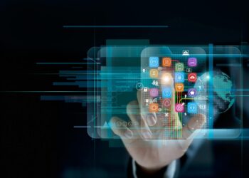 A hand interacts with a transparent touch screen displaying various colorful app icons on the Fintechzoom Official Website. The background features futuristic digital graphics and a partial globe, symbolizing global communication and technology. Dark, modern tech-themed aesthetic. | FintechZoom