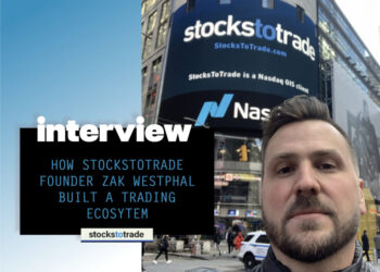 A man takes a selfie in front of a large digital billboard displaying the "Stockstotrade" and Nasdaq logos in Times Square. The overlay text reads, "Interview: How Stockstotrade founder Zak Westphal built a trading ecosystem. | FintechZoom