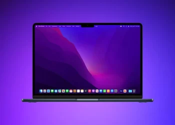 A sleek laptop with a vibrant screen displaying a colorful, abstract wallpaper in shades of purple and red. The desktop shows various icons and an application toolbar at the bottom, one of which is designed to remove malware. The background has a gradient from blue to purple. | FintechZoom