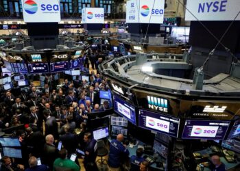 Traders crowd the floor of the New York Stock Exchange (NYSE). The floor features multiple monitors displaying financial data and the NYSE logo. Several screens also show the logo for Sea Limited, indicating its prominence in a trading session closely watched by S&P 500 investors. | FintechZoom