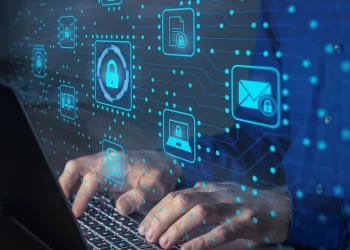 A person types on a laptop with security icons, including a lock, email, and user, floating in front of them. The icons are overlaid in a blue, high-tech digital interface, suggesting concepts of ISP Proxies, cybersecurity, and data protection. | FintechZoom