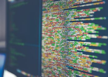 A close-up of a computer screen displaying colored lines of code, showcasing different syntax elements in various hues. The focus is on the central part, slightly blurred at the edges, highlighting data scraping algorithms running through the vibrant display. | FintechZoom