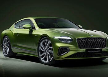 A sleek green luxury sports car, the new Bentley Continental GT, is parked on a smooth surface against a dark green background. It has a distinctive front grille, stylish headlamps, and large silver alloy wheels. | FintechZoom