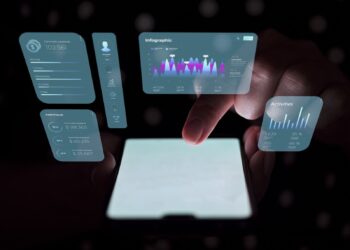 A person uses a web app on their smartphone with holographic data displays projected above it. The holograms show various statistics, charts, and graphs, including communication details, an infographic, portfolio values, and recent activities. The background is dark. | FintechZoom