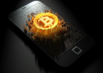 A smartphone with a digital representation of a Bitcoin symbol emerging from the screen. The bright gold, pixelated style contrasts against the dark background and black smartphone, symbolizing the rise of Bitcoin casinos. | FintechZoom