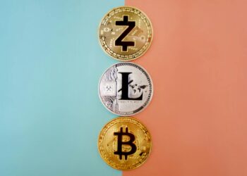 Three cryptocurrency coins aligned vertically against a two-toned background (orange on the right, green on the left). From top to bottom: Zcash with a "Z" symbol, Litecoin with an "L" symbol, and Bitcoin with a "B" symbol—perfect for transactions in crypto casinos. | FintechZoom