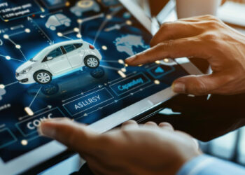 Close-up of hands navigating a tablet with a digital interface, showcasing a 3D car model and insurtech data points. The screen highlights technical options and a world map, seamlessly integrating insurance technology insights into automotive design. | FintechZoom