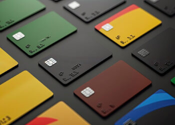 A variety of credit cards in different colors, including green, yellow, black, red, and brown, are arranged in a grid pattern on a dark surface. Each card features a chip, a contactless payment symbol, and embossed numbers. No brand logos are visible. Check out FintechZoom.com Best Credit Cards for more options! | FintechZoom