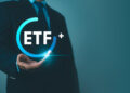 A person in a suit holds a glowing blue circle with the text "ETF+" inside, symbolizing financial or investment opportunities related to Exchange-Traded Funds. Set against a gradient of dark teal to light teal, this scene evokes the dynamic synergy between FintechZoom.com and Crypto ETF innovations. | FintechZoom