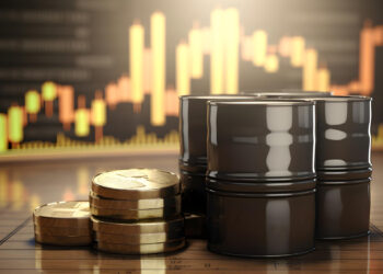 Stacks of gold coins and oil barrels rest on a wooden surface, symbolizing the dynamic world of FintechZoom.com Commodities Market . In the background, a blurred financial graph with rising bars highlights the commodities market's impact on current market trends. | FintechZoom