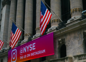 The New York Stock Exchange building with American flags and large columns. A pink and purple banner with the Instagram logo reads "@NYSE TAG US ON INSTAGRAM. | FintechZoom