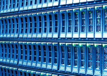 A close-up view of blue network servers with rows of rack-mounted units and glowing LED indicators, showcasing a modern data center environment optimized for Web3 applications. | FintechZoom