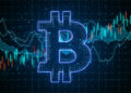 A glowing blue Bitcoin symbol is centered over a background featuring a digital chart with fluctuating lines and candlestick patterns. The chart represents financial or cryptocurrency market trends. | FintechZoom