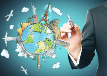 A hand in a suit draws a stylized globe with iconic landmarks like the Statue of Liberty, Eiffel Tower, and Big Ben. Airplanes and clouds encircle the globe, symbolizing global travel. The background is a gradient of blue, inviting you to travel the world. | FintechZoom