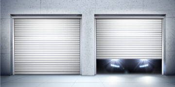Two white roll-up garage doors on a modern building; one door is fully closed, while the other is partially open with headlights from a car shining out from behind it. | FintechZoom