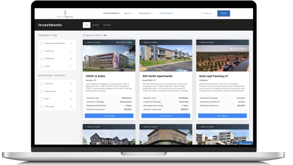 A laptop screen displays a real estate investment app featuring property listings with images, descriptions, filters for property type and strategy, plus buttons to view details or invest. | FintechZoom