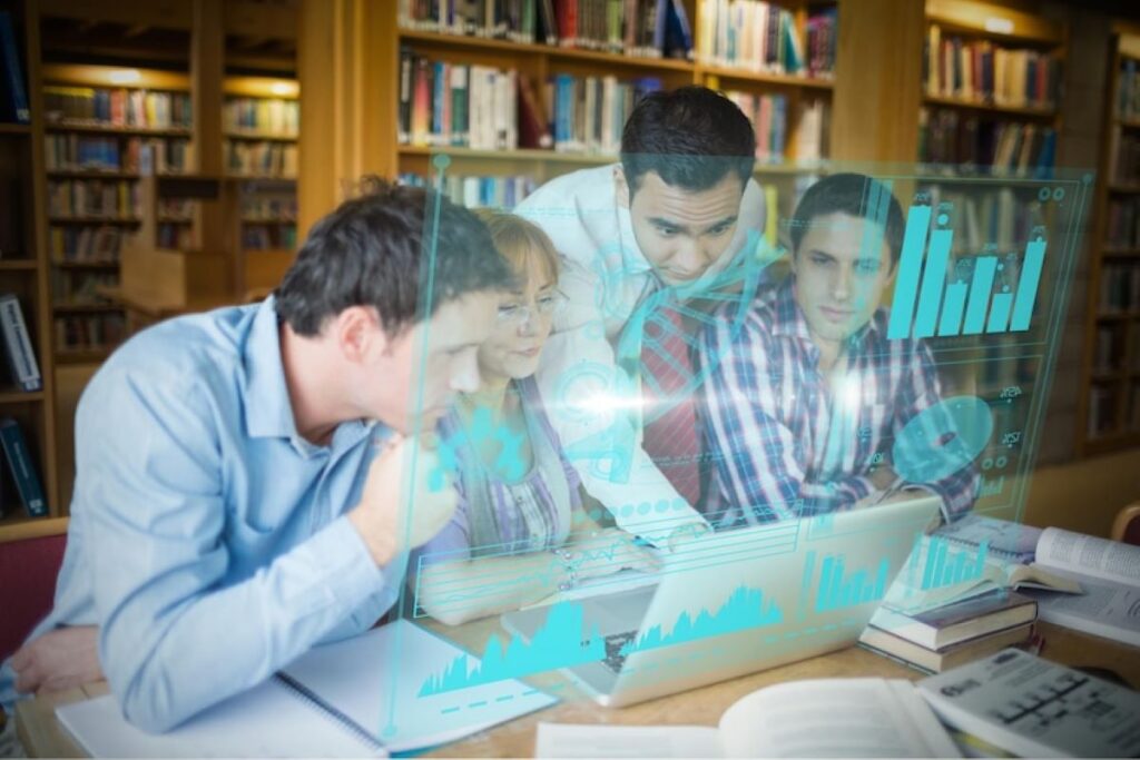 Four people sit at a library table, looking at a laptop with futuristic holographic charts and graphs projected in front of them. The background is filled with bookshelves and open books. | FintechZoom - 92 percent of university students used generative AI for academic purposes in 2025, up from 66 percent in 2024.