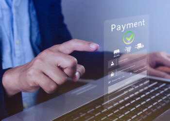 A person uses a laptop and interacts with a transparent virtual screen displaying a payments interface, featuring icons for online shopping, login fields, and a green checkmark above the word "Payment. | FintechZoom