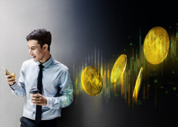 A man in business attire holding a phone and coffee cup smiles, with digital Bitcoin coins and a rising financial chart graphically overlaid beside him, suggesting cryptocurrency trading or investment. | FintechZoom